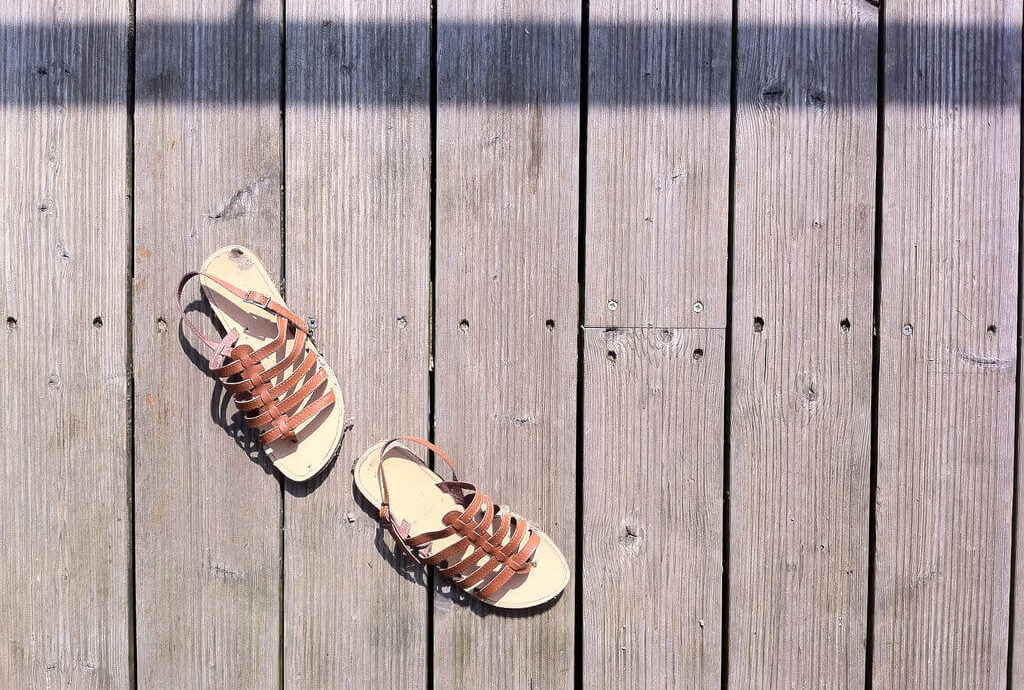 sandales tropéziennes marron sur terrasse en bois